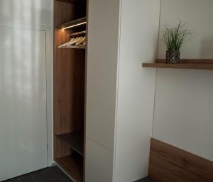 a walk in closet with white walls and wooden shelves at Guest House Tri Zvezde in Kočevje