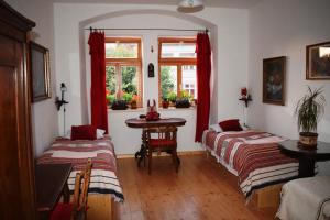 Zimmer mit 2 Betten, einem Tisch und einem Fenster in der Unterkunft Rychta in Rataje nad Sázavou