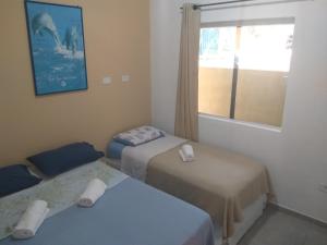 Habitación con 2 camas y ventana en Casa do Mar & Ane Ilhabela en Ilhabela