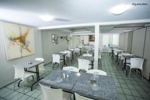 een eetkamer met tafels en witte stoelen bij HOTEL ZURIQUE in Patos