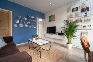 sala de estar con mesa y pared azul en Vakantiehuis Vieverdwas - Yerseke, en Yerseke