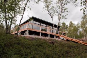 dom na szczycie wzgórza z drzewami w obiekcie Villa Váibmu w mieście Inari