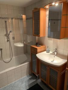 uma casa de banho com uma banheira, um lavatório e um chuveiro em Haus Huberta em Achenkirch
