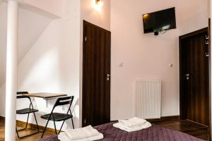 a bedroom with a bed and a table and a tv on the wall at Villa 37b Bed and Breakfast in Warsaw
