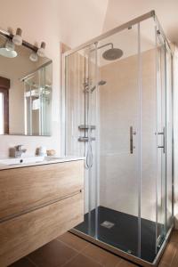a glass shower in a bathroom with a sink at Apartamentos LA PARRA in Buitrago del Lozoya