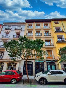 Dos coches aparcados delante de un edificio en Morar Apartments Malasaña, en Madrid