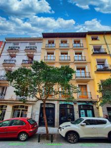 Morar Apartments Malasaña في مدريد: سيارتين متوقفتين امام مبنى