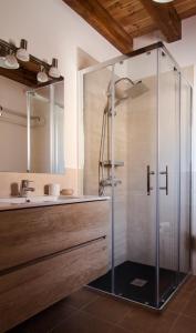 y baño con ducha de cristal y lavabo. en Apartamentos LA PARRA, en Buitrago del Lozoya