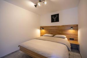 a bedroom with a bed with a wooden headboard at Chilly apartment in Bled
