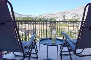 a table and chairs on a balcony with a view at Korali in Symi