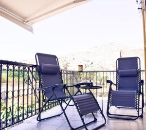 two chairs sitting on a balcony with a view at Korali in Symi