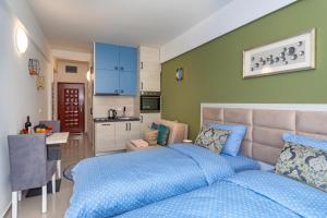 a bedroom with a blue bed and a kitchen at Sea&Center Lux in Bar