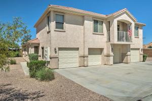 a brick house with two garage doors and a flag at Dtwn Mesquite Condo with Resort Pool Golf and Gamble! in Mesquite