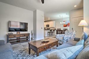 a living room with a couch and a tv and a table at Dtwn Mesquite Condo with Resort Pool Golf and Gamble! in Mesquite