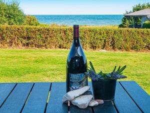 a bottle of wine sitting on a picnic table with a plant at 10 person holiday home in Allingåbro-By Traum in Nørager
