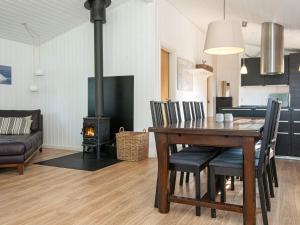 jadalnia i salon ze stołem i piecem opalanym drewnem w obiekcie 6 person holiday home in Juelsminde w mieście Juelsminde