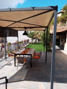 un patio con mesa y sillas bajo un dosel en Casa rural La Media Legua, en Villoslada de Cameros