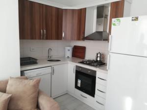 eine Küche mit einem weißen Kühlschrank und einem Herd in der Unterkunft Dalaman Airport Daltur Aparts in Dalaman