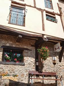 een bank voor een gebouw met ramen bij Casa rural La Media Legua in Villoslada de Cameros