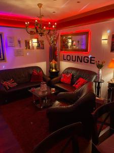 a living room with leather couches and red lighting at Chez-Ronny in Hamburg