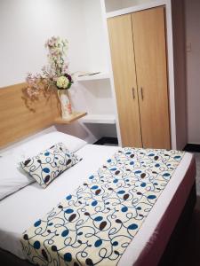 1 dormitorio con 1 cama y un jarrón de flores en Hotel Plaza 43, en Barranquilla