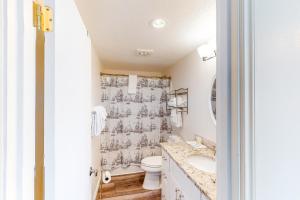 a bathroom with a toilet and a shower curtain at Shearwater House and Studio in Lincoln City