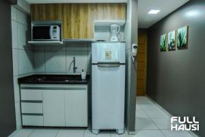 eine kleine Küche mit einem Kühlschrank und einer Mikrowelle in der Unterkunft Estudio no West Flat Mossoró - Alto Padrão in Mossoró