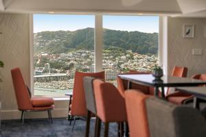 a restaurant with a table and chairs and a large window at James Cook Hotel Grand Chancellor in Wellington
