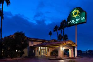 ein Schild für den Gasthof aahuilla mit Palmen in der Unterkunft La Quinta Inn by Wyndham Phoenix Thomas Road in Phoenix