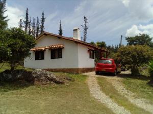 a red car parked in front of a house at Villa Lourdes in Villa de Leyva