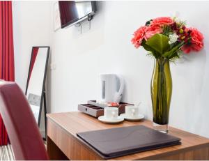a vase of flowers sitting on top of a table at Green View Hotel Near Dartford in Dartford