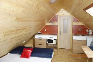 a small room with a bed and a kitchen at Apík u Milušky in Mikulovice