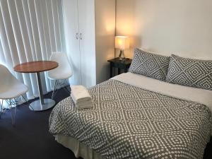 1 dormitorio con 1 cama, mesa y sillas en Cityview Studio Accommodation en Sídney
