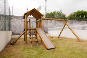 - une aire de jeux en bois avec un toboggan et une échelle dans l'établissement Apto Ubatuba Sun Way 3302, à Ubatuba