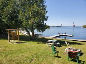 a park with chairs and a picnic table and a dock at Steffen's Cedar Lodge in Washington Island