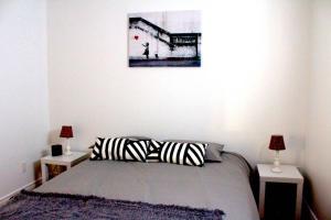 a bedroom with a bed with two lamps and a painting at Chalet l'Authentique: Massif, Spa et Plein Air in Petite-Rivière-Saint-François