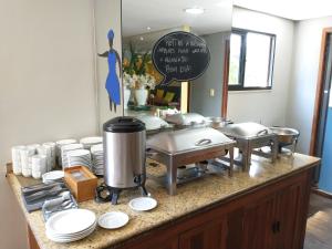 uma cozinha com um balcão com pratos em Flat Athenas 611 em Salvador
