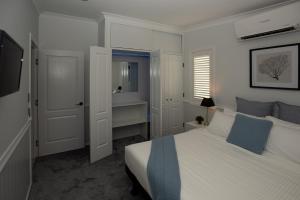 a white bedroom with a bed and a sink at Bella Vista Stanthorpe in Stanthorpe