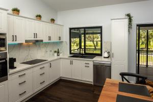 a white kitchen with white cabinets and a window at Bella Vista Stanthorpe in Stanthorpe