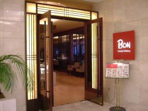 una puerta abierta a un edificio con un cartel. en Takaoka Manten Hotel Ekimae, en Takaoka