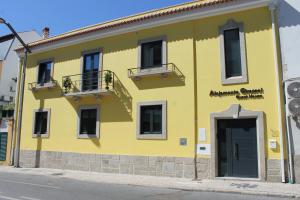 un edificio amarillo al lado de una calle en Alojamento Girassol, en Castelo Branco