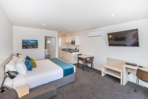 ein Schlafzimmer mit Bett und Schreibtisch und eine Küche in der Unterkunft Taylors Motel in Ashburton