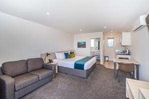 ein Hotelzimmer mit einem Bett und einem Sofa in der Unterkunft Taylors Motel in Ashburton
