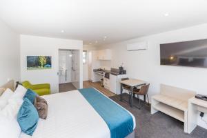 1 dormitorio con cama, escritorio y cocina en Taylors Motel, en Ashburton