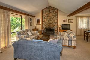 a living room with two couches and a stone fireplace at Camelot Cottage in Blackheath