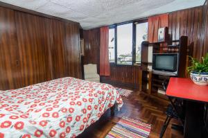 a bedroom with a large bed and a television at Arequipay Backpackers Downtown in Arequipa