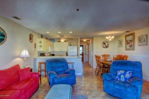 uma sala de estar com um sofá e cadeiras e uma cozinha em LUXURY 2BR OCEAN VIEW CONDO - VILLA CAPRIANI RESORT - SLEEPS UP TO 10 em North Topsail Beach
