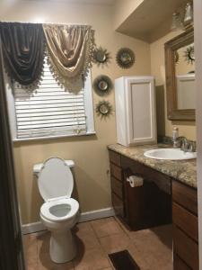 ein Badezimmer mit Toilette und Waschbecken und einem Fenster in der Unterkunft ONE OF THE BEST BARGAINS IN TOWN 50.00 A DAY in Montgomery