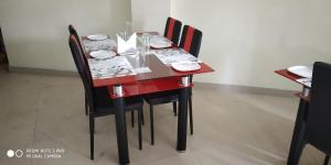 czerwony stół z czarnymi krzesłami i płytami w obiekcie Hotel Landmark w mieście Port Blair