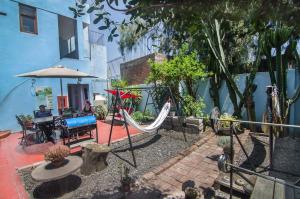 eine Terrasse mit einer Hängematte sowie einem Tisch und Stühlen in der Unterkunft Arequipay Hostel in Arequipa